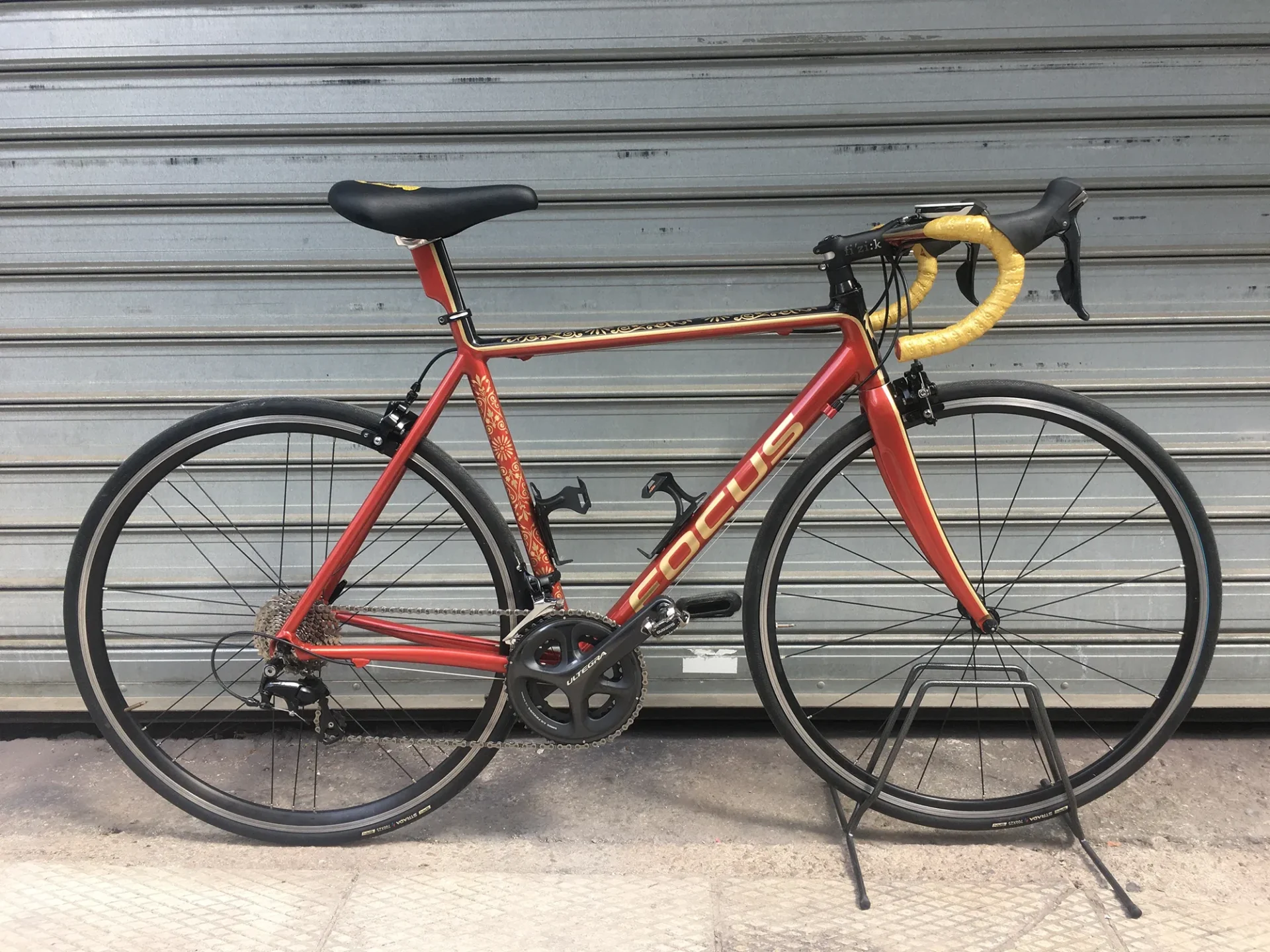 Custom painted Focus ποδήλατο δρόμου σε κόκκινο και χρυσό.